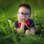 Child wearing glasses in need of myopia management, showcasing effective eye care.