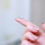 Close-up of a contact lens on a finger, showcasing drug-eluting technology